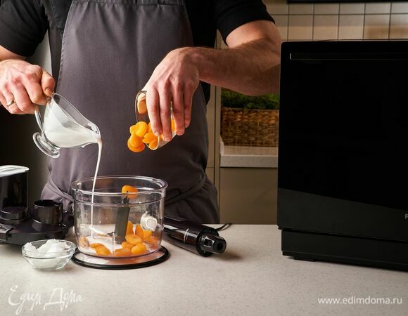 Приготовьте крем. В чашу блендера положите курагу, кокосовое масло и влейте сливки. Измельчите все с помощью погружного блендера Panasonic до однородной консистенции.