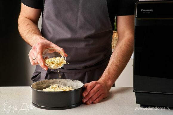 Форму диаметром 20 см смажьте сливочным маслом. Вылейте тесто и сверху равномерно посыпьте миндальными лепестками.