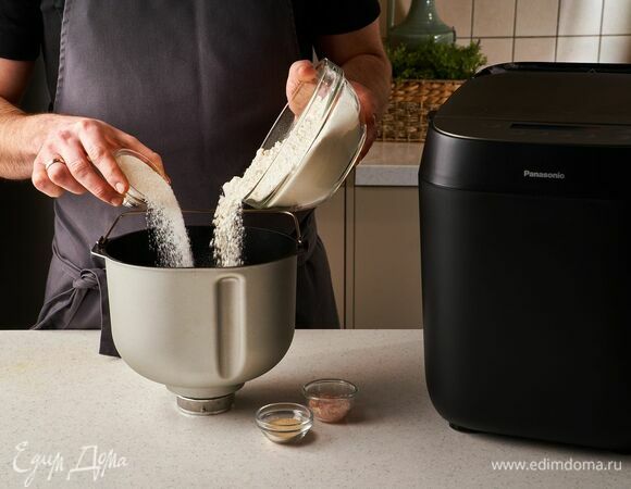 Насыпьте в ведро хлебопечи сухие дрожжи, муку, сахар, соль, молотую корицу и ванильный сахар.