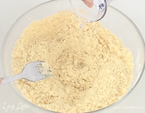 Перетереть в крошку при помощи вилки. Добавить холодную воду и собрать тесто в шар. Если тесто не соберется в шар, допустимо добавить еще 10 мл воды.