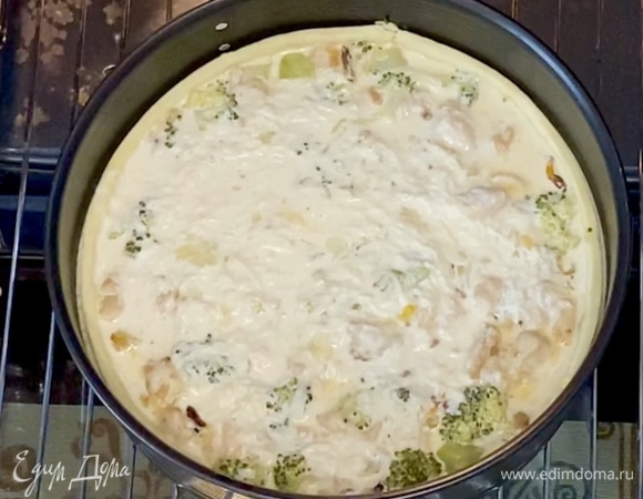 Далее достать тесто из духовки или выдвинуть решетку. В тесто уложить начинку, а затем вылить заливку, распределить по всей поверхности. Снова отправить в духовку на 25 минут, готовить до румяности.