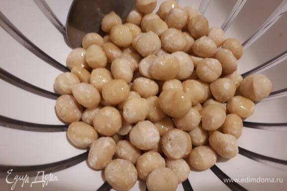 Выложите орехи в миску, влейте оливковое масло и хорошо перемешайте.