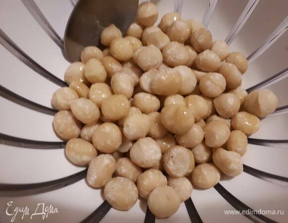 Выложите орехи в миску, влейте оливковое масло и хорошо перемешайте.