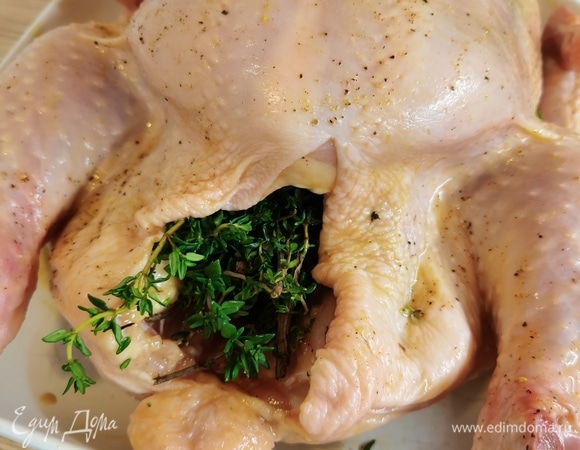 Обмазываем курицу тщательно снаружи и внутри получившимся маринадом. Тем самым мы улучшим вкус курицы и закупорим проколы, поэтому соус не вытечет из нее. Посыпать свежемолотым душистым перцем. Зелень помыть и немного помять,чтобы она выделила аромат. Уложить зелень в брюшко курицы. Зелень берите любую, какую любите (укроп, петрушку, розмарин, зеленый лук, любисток). У меня тимьян. Аромат от него сумасшедший!