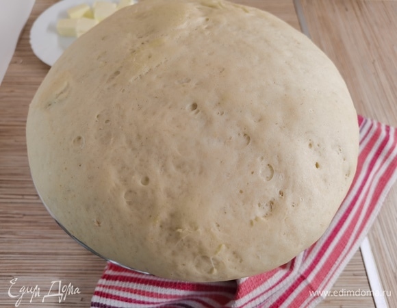 В глубокой миске смешать половину муки с дрожжами. Влить остывшее молоко с маслом, теплую воду и вбить яйца. Тщательно перемешать. Постепенно ввести оставшуюся муку и замесить эластичное мягкое тесто. На это уйдет примерно 10 минут. Можно воспользоваться тестомесом (насадка крюк). Прикрыть тесто полотенцем и дать ему подняться в теплом место примерно 30 минут.