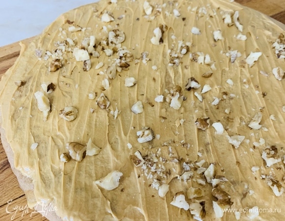 Каждый корж промазать кремом и посыпать мелко нарубленными орехами (кроме последнего верхнего).