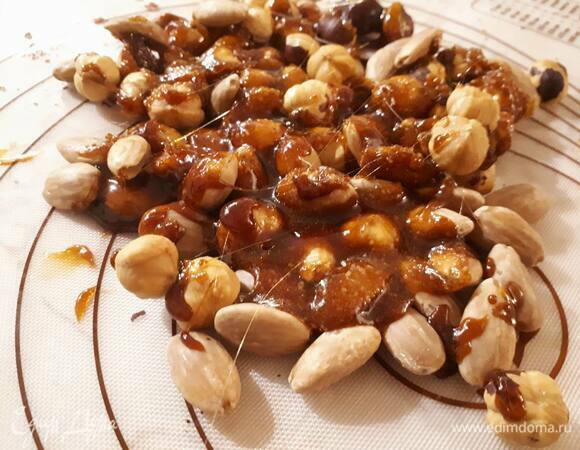 Снимите карамель с огня и сразу же вылейте на орехи. Дайте немного остыть (минут 10–15).