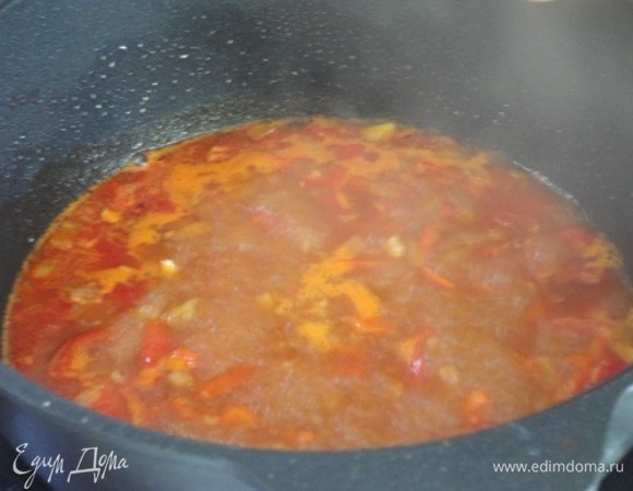 В оставшемся жире обжарить мелко нарезанный лук, добавить нарезанные помидоры (летом используйте 1 свежий помидор среднего размера) и красный болгарский перец, также нарезанный на небольшие кусочки. Сверху на овощи (не на сковороду!) высыпьте паприку, через пару секунд перемешайте и залейте 200 мл воды.