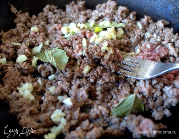 Когда фарш немного схватится, добавить специи, чеснок, лавровый лист.