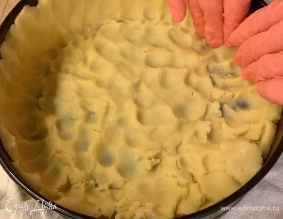 Тесто достаньте из холодильника и равномерно распределите по форме, сформируйте бортики до верха.