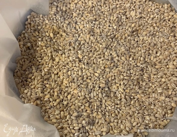 Сверху положите пергамент и всыпьте груз (горох, фасоль, крупа) до самого верха (чтобы тесто не поднималось в духовке). Выпекайте основу в разогретой духовке при 200°C 20 минут. Затем уберите груз и охладите 15 минут.