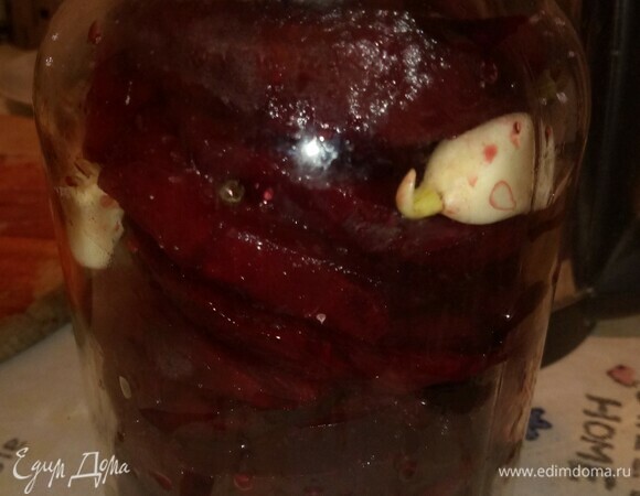 Накрываем крышкой, оставляем на 3 часа, чтобы свекла пустила сок. По прошествии времени заливаем водой. Закрываем крышкой, ставим банку в миску с высоким краем. Оставляем при температуре 20–25°C для сквашивания на 12–14 дней. Каждые 2 дня открываем крышку и немного мешаем тонкой бамбуковой палочкой, не смещая слои (чеснок не должен плавать на поверхности). Со временем на поверхности будут появляться пузырьки. Примерно когда чеснок станет темно-лиловым, тогда квашеная свекла будет готова.