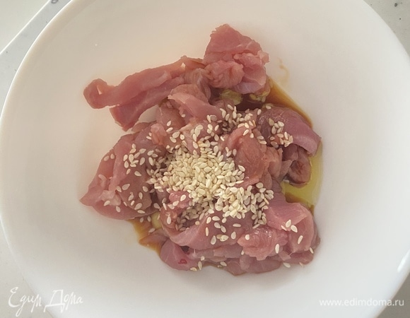 Филе индейки (у меня филе бедра) нарезать максимально тонко брусочками. Добавить к мясу кунжут, соевый соус, свежемолотый перец и оливковое масло. Перемешать и оставить мариноваться на 20–30 минут. Затем обжарить на сковороде, помешивая, до румяной корочки. Недолго, иначе будет сухим.