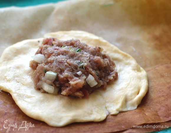 Тесто разделить на небольшие кусочки (50–70 г), сформировать 14–16 шариков. Раскатать тесто толщиной 3–4 мм, выложить начинку по 1 ст. л. с горкой. Скрепить верх по кругу, оставляя дырочку.
