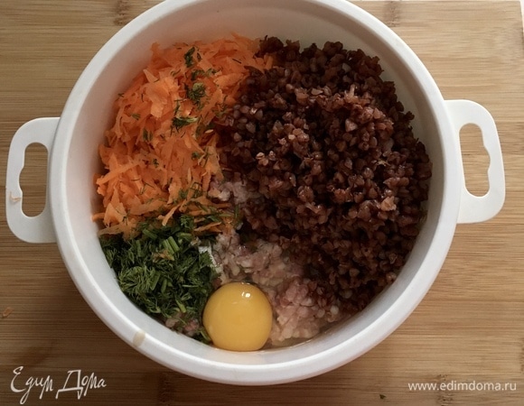 К фаршу добавляем натертую на крупной терке морковь, мелко нарезанный лук, зелень, отварную гречку (указано 100 г гречки в сухом виде), яйцо, соль, черный перец и специи для свинины по вкусу. Перемешать до однородности.