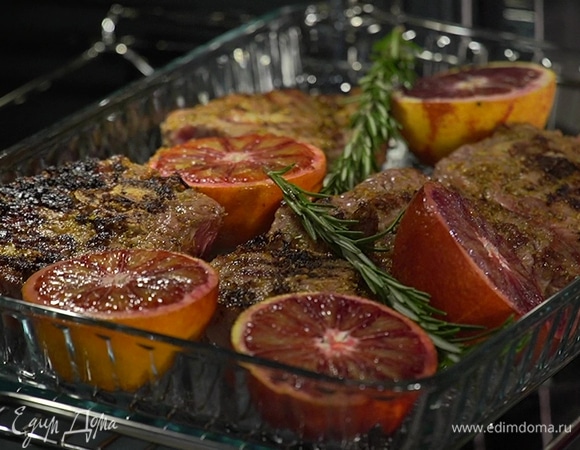 Переложить обжаренное мясо в форму с апельсинами, сверху выложить веточки розмарина, рядом поместить шалот и чеснок, полить все оливковым маслом.