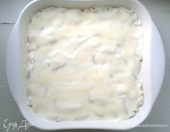 Сметану разровнять ложкой и посыпать сахаром. Поставить форму в духовку, разогретую до 180°C, на 20–25 мин.