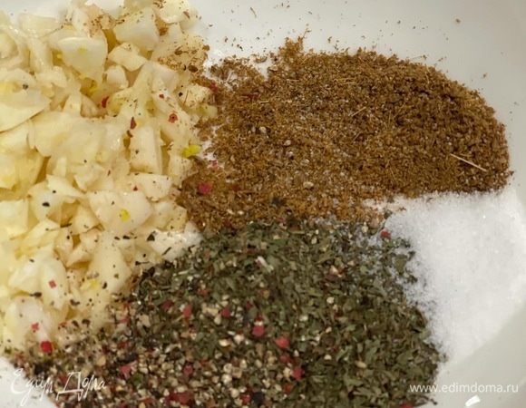 Моем и обсушиваем ребра. Мелко рубим чеснок, смешиваем со специями и натираем ребра.