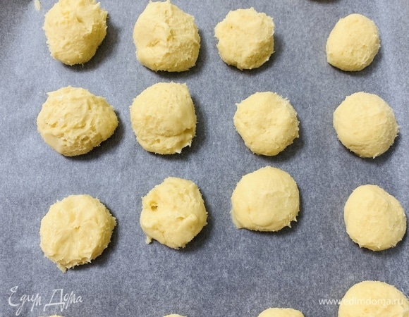 Сразу после холодильника слепить из теста одинаковые шарики диаметром 4–6 см и разложить их на противень, покрытый пекарской бумагой.