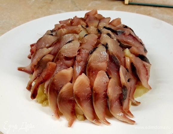 Селедку почистить от внутренностей и косточек. Нарезать тонкими полосками. Уложить поверх картошки.