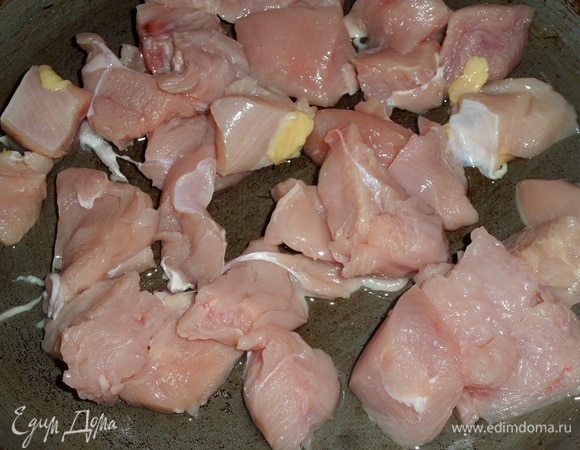 В разогретую сковороду наливаем растительное масло. Выкладываем нарезанное куриное филе.