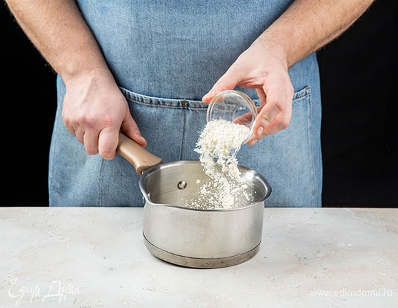 Приготовьте сливочный соус. В сухом сотейнике обжаривайте муку около 1 минуты, помешивая.