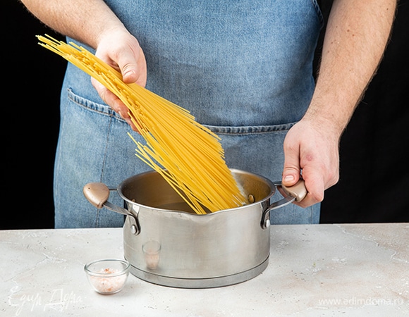 Отварите спагетти в подсоленной воде до состояния альденте. Воду слейте в отдельную емкость и сохраните. А спагетти верните в кастрюлю и накройте крышкой.