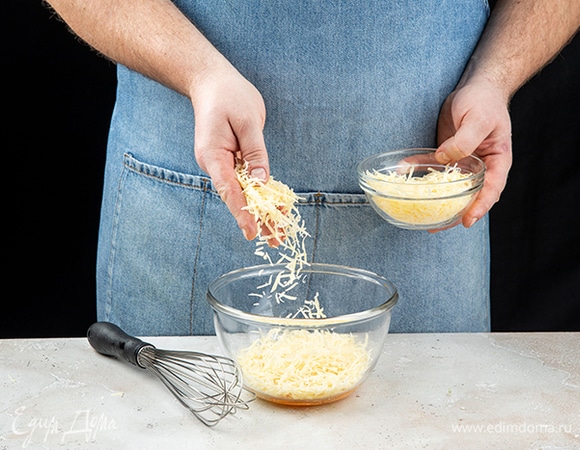 Для соуса в глубокой емкости соедините желтки и тертый сыр, тщательно перемешайте венчиком.