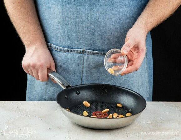 Слейте воду, просушите орехи на сухой горячей сковороде. 