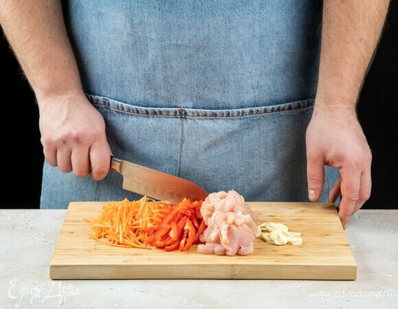 Куриное филе, морковь и болгарский перец нарежьте на небольшие кусочки. Чеснок мелко порубите.