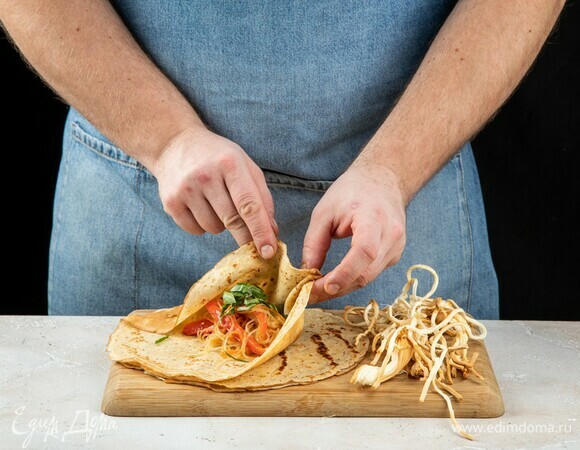 На середину блина выложите курицу с фунчозой. Получившейся начинки хватает на 10–12 блинов. 