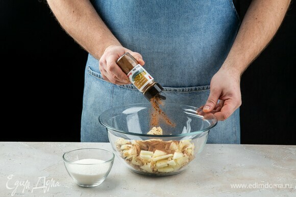 Выложите яблоки и орехи в миску. Добавьте корицу молотую ТМ «Ашан» и сахар. Перемешайте.