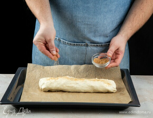 Смажьте поверхность рулета остатками сливочного масла и чуть обсыпьте сахаром. Выпекайте в духовке при 180°C окло 30–35 минут до золотистого цвета.