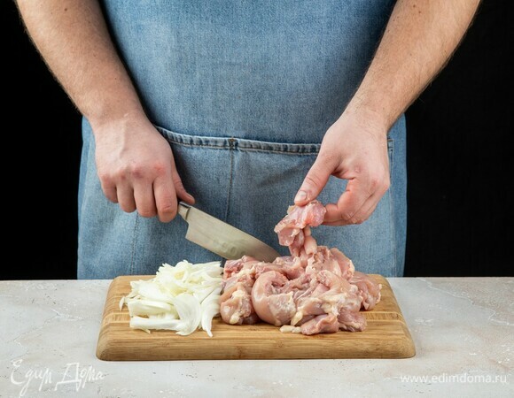 Лук почистите и крупно порубите. Куриные бедра нарежьте средними кусочками. Прокрутите на самой мелкой насадке мясорубки.