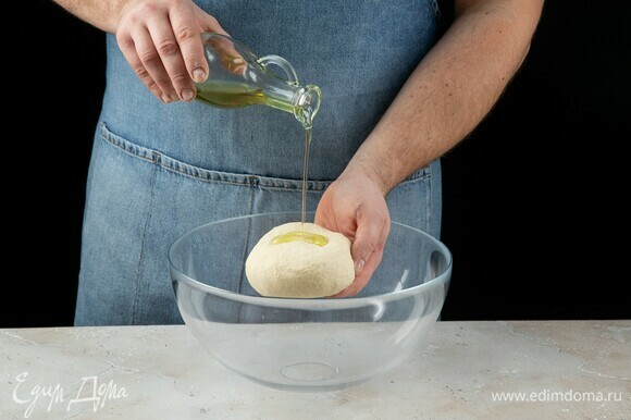 Полученное тесто слегка полейте оливковым маслом, оставьте подходить на один час.