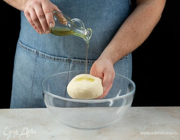 Полученное тесто слегка полейте оливковым маслом, оставьте подходить на один час.