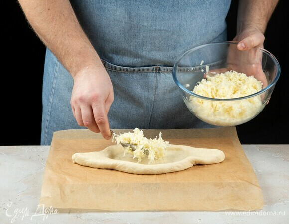 Тесто раскатайте, сформируйте лодочку, выложите сыр.