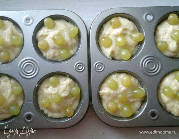 В каждый кекс вставить по 5–6 виноградин, слегка утапливая их в тесте.