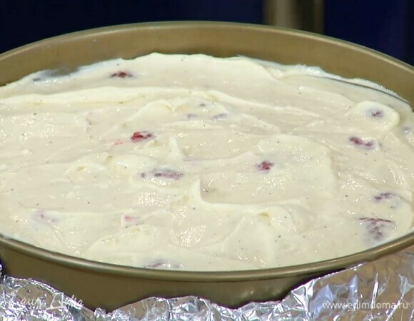 Половину малины добавить в сливочную массу и перемешать, затем выложить все в форму с охлажденным коржом и равномерно распределить.