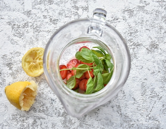 В емкость поместить оставшуюся клубнику и веточки базилика.