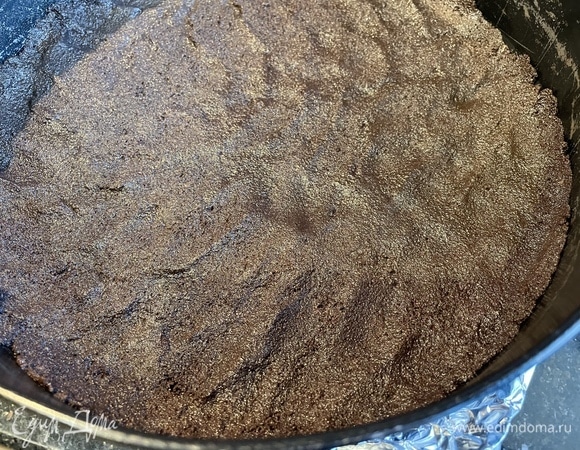 Выложите полученную массу на дно разъемной формы и разровняйте. Форму предварительно застелите пергаментом. Поставьте в холодильник.