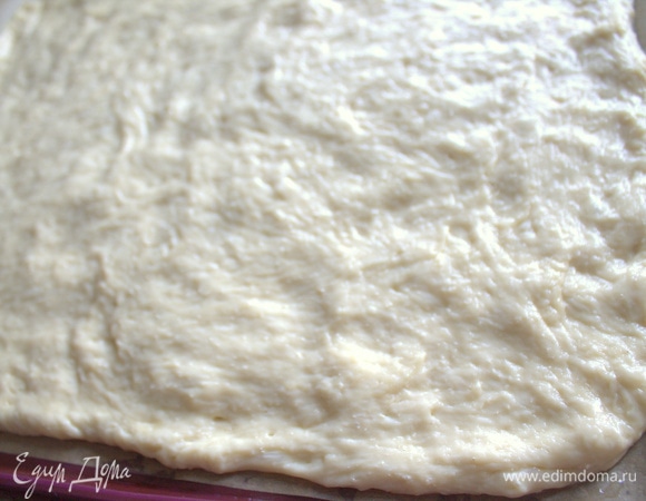 Смазать руки растительным маслом и растянуть тесто на противне с бумагой для выпечки. Это будет невысокий пирог.