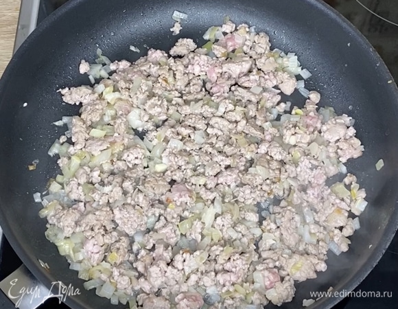 Готовим начинку. На разогретую сковороду влить растительное масло. Лук и чеснок измельчить и отправить в сковороду. Обжарить до мягкости лука. Добавить фарш (любой на ваш вкус, у меня — из голени индейки), обжаривать в течение 5 минут.