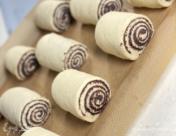 Готовое тесто раскатать в пласт толщиной 1,5 см. Распределить маковую начинку. Свернуть в рулет. Разрезать на равное количество булочек. Выпекать при 180°C 25 минут.