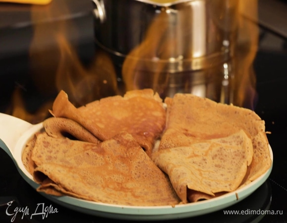 По желанию добавьте «огонька» в блюдо. Сильно нагрейте сковороду, блинчики сверните треугольником и выложите на нее, оставляя свободное место в центре. Вылейте в середину ликер и подожгите. Дайте алкоголю выпариться и снимите блинчики с огня.