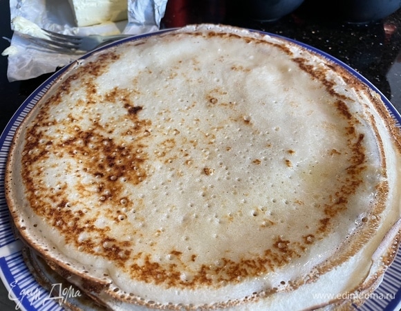 На раскаленной сковороде, смазанной растительным масло, пожарьте блинчики. Складывайте блины стопкой, смазывая каждый сливочным маслом.