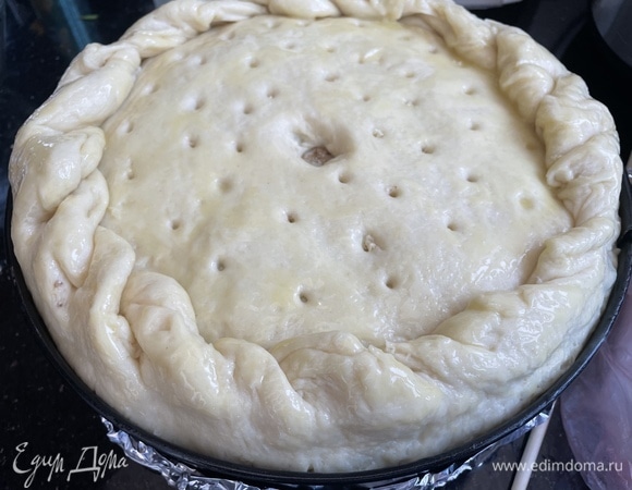 Закройте оставшимся раскатанным тестом, сделайте дырочки для выхода пара. Смажьте желтком. Выпекайте в предварительно нагретой до 180°C духовке 45 минут.