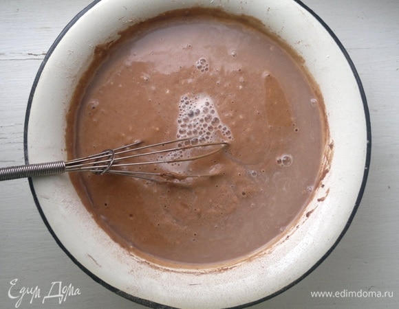 Порциями добавить просеянную муку, соду, какао, перемешать. Добавить теплую кипяченую воду, перемешать тесто до однородности. Воду вливайте небольшими порциями до получения теста консистенции кефира, ее может потребоваться больше или меньше.