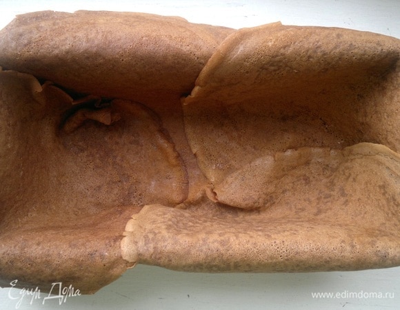 Прямоугольную форму для выпечки застелить пергаментом, смазать растительным маслом. Выложить в форму внахлест 4 блинчика. Стыки блинчиков смазать взбитым яйцом.