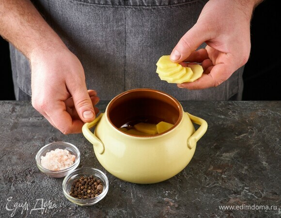 Возьмите горшочки. Выложите слой картошки, посолите, поперчите.